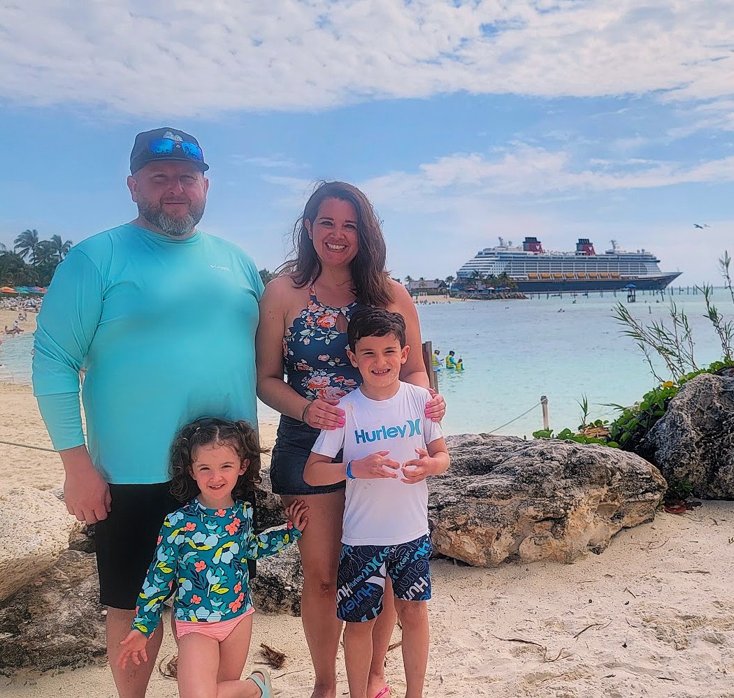 Family on the beach with the Disney Dream cruise ship in the background