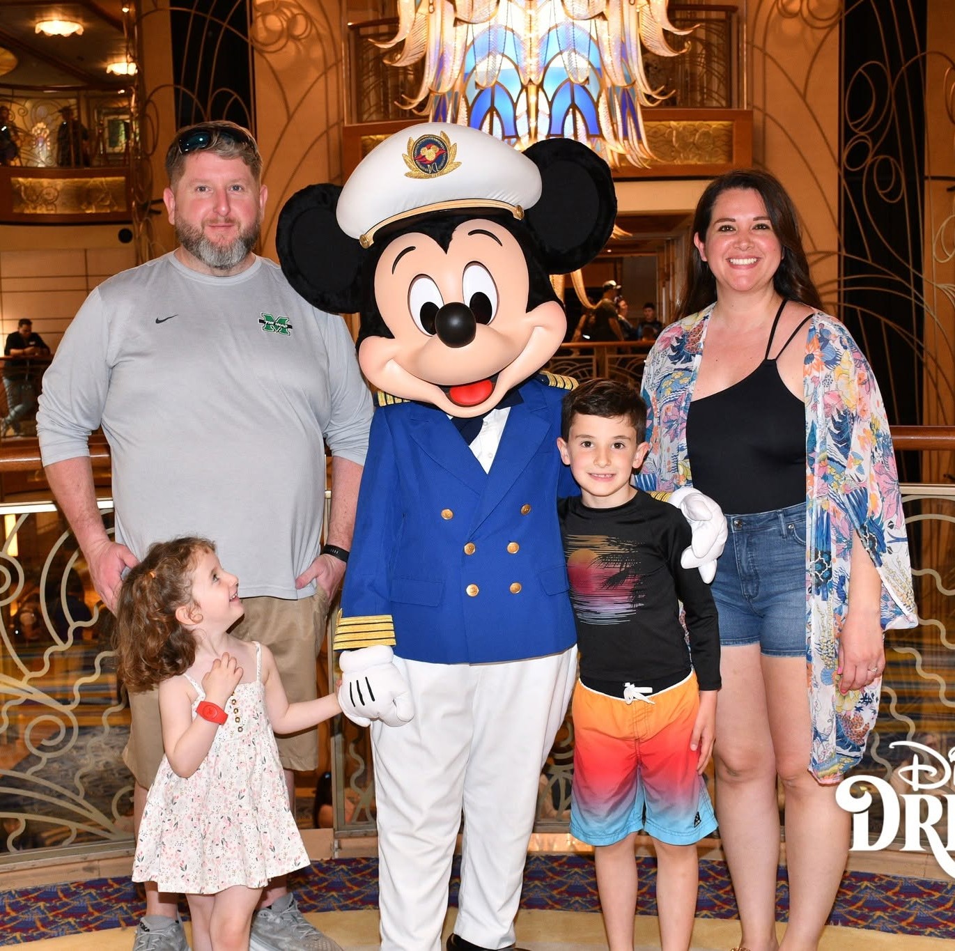Family taking a photo with Captain Mickey aboard a Disney cruise